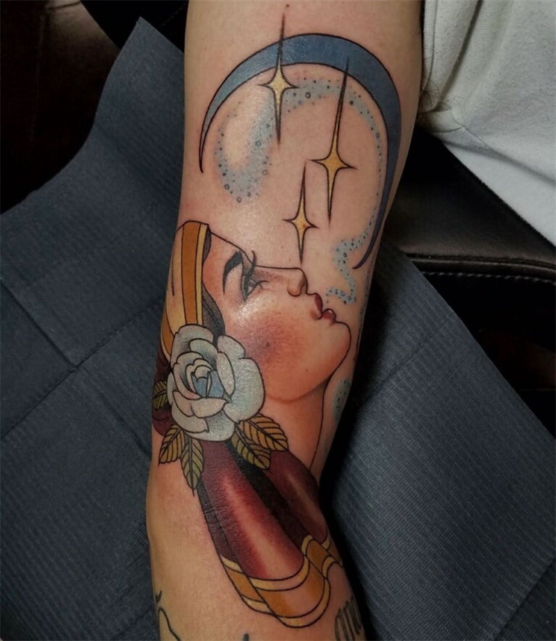 Woman looks at moon tattoo